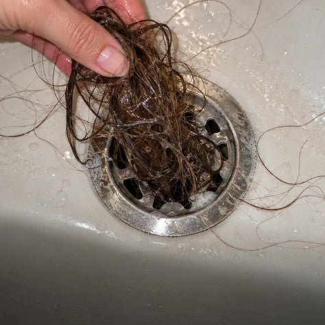 Capelli raccolti nello scarico della doccia
